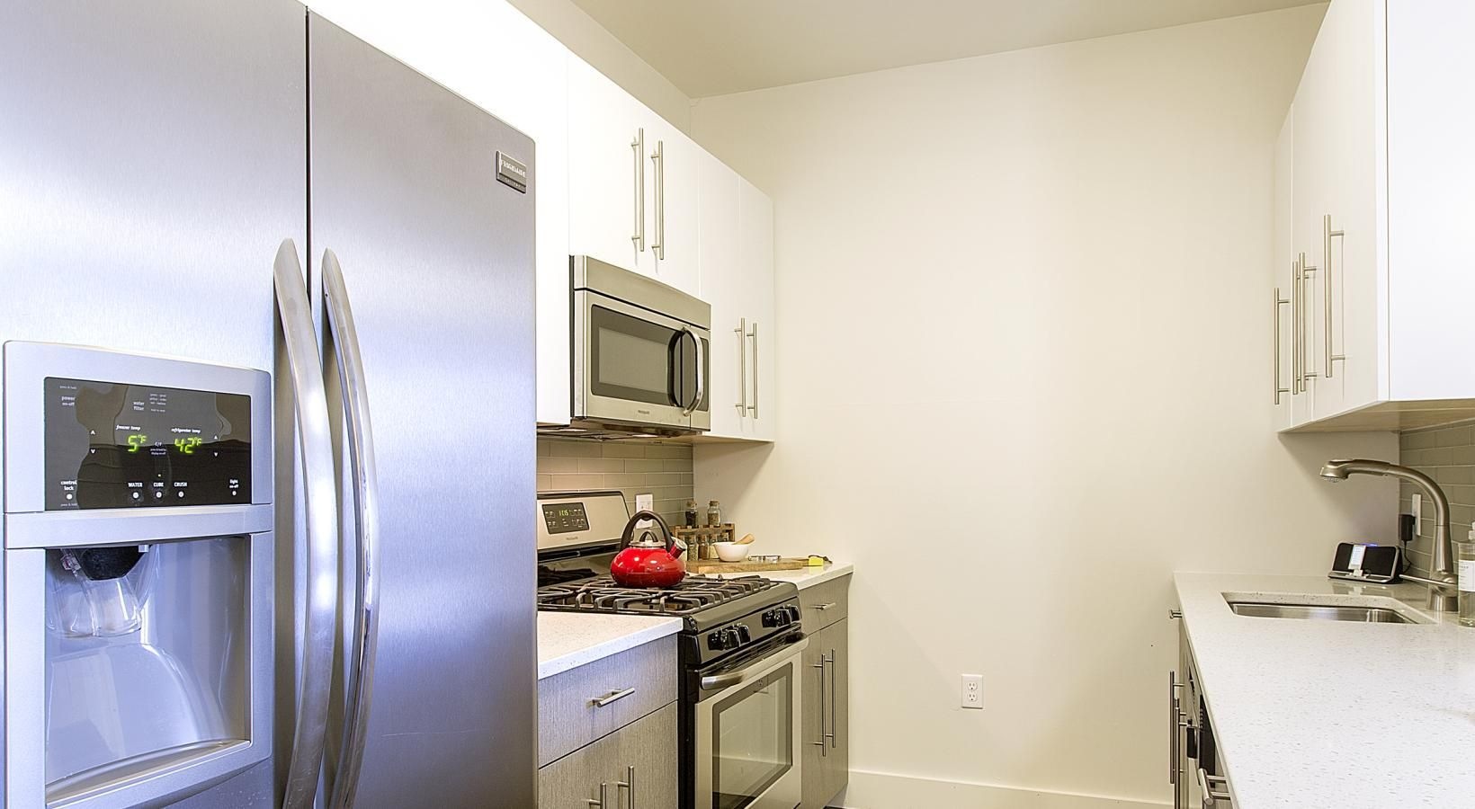 Spacious kitchens with thoughtful details a kitchen with a refrigerator and microwave