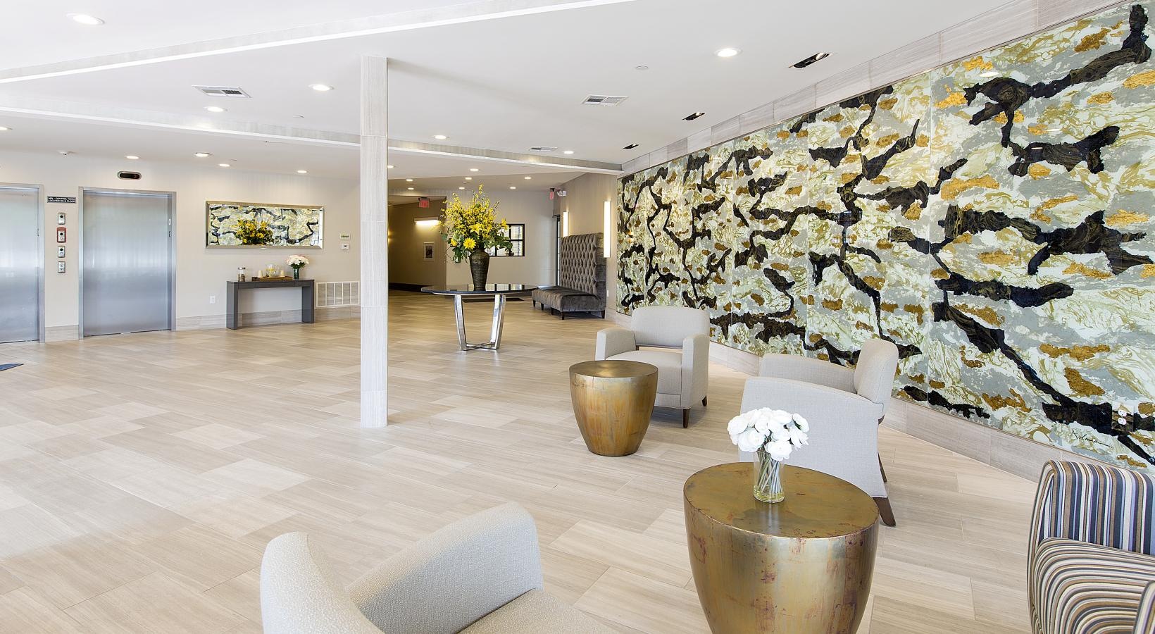 Settle into comfort at Gatehouse 75 a large room with white chairs and a large vase with flowers