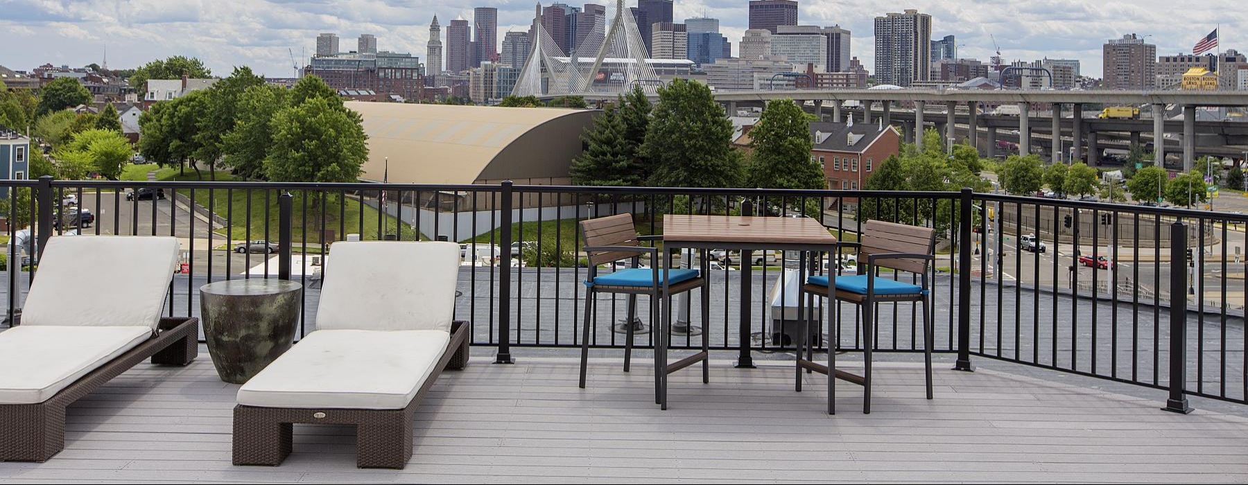 a deck with chairs and tables and a city in the background