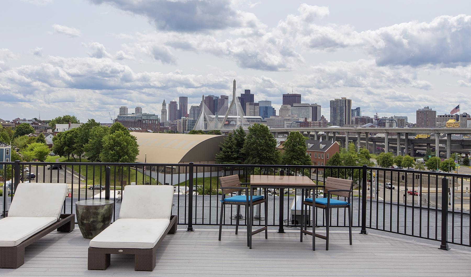 a deck with chairs and tables and a city in the background